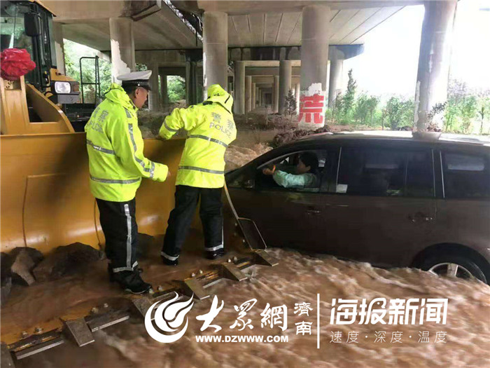 越野车积水中熄火驾驶员被困 交警开铲车